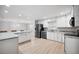 Bright kitchen with stainless steel appliances, white cabinets, stone countertops, and wood flooring at 707 Laurel Pointe Ct, Lakeland, FL 33813