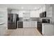 Modern kitchen featuring stainless steel appliances, white cabinets, stone countertops, and wood floors at 707 Laurel Pointe Ct, Lakeland, FL 33813