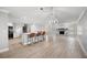 Open floor plan features wood floors, a stone fireplace, kitchen island with seating, and a chandelier at 707 Laurel Pointe Ct, Lakeland, FL 33813