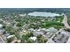 Aerial view of a neighborhood with a pond, lush foliage, and commercial and industrial buildings in the distance at 716 S Franklin Pl, Lakeland, FL 33815