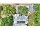 Aerial view of a home with solar panels, mature trees, a driveway, and a detached garage at 716 S Franklin Pl, Lakeland, FL 33815