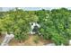 Aerial view of a two-story home surrounded by mature trees with a circular driveway and lush landscaping at 716 S Franklin Pl, Lakeland, FL 33815