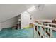 Large attic space with built-in shelving, white walls, and teal carpeting at 716 S Franklin Pl, Lakeland, FL 33815