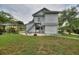 Exterior view of a two-story house featuring a backyard, green lawn, and a staircase at 716 S Franklin Pl, Lakeland, FL 33815
