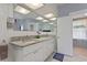 Bathroom showcasing double sinks, granite countertops, and a large, illuminated mirror at 716 S Franklin Pl, Lakeland, FL 33815