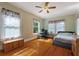 Bright bedroom with hardwood floors, floral curtains, and an office space with desk setup at 716 S Franklin Pl, Lakeland, FL 33815