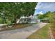 Charming two-story home with a covered front porch, lush landscaping, and a long driveway at 716 S Franklin Pl, Lakeland, FL 33815