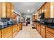 Expansive kitchen featuring wooden cabinets, black countertops, and stainless steel appliances, ideal for culinary creations at 716 S Franklin Pl, Lakeland, FL 33815