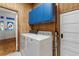 Practical laundry room with wooden accents, featuring a washer, dryer, and blue upper cabinets at 716 S Franklin Pl, Lakeland, FL 33815