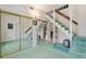 Spacious living room with a staircase, mirrored closet doors, and blue-green carpeting at 716 S Franklin Pl, Lakeland, FL 33815