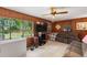 Comfortable living room with wood paneling, large windows, and entertainment setup at 716 S Franklin Pl, Lakeland, FL 33815