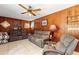 Relaxing living room featuring wood paneling, plush seating, and a ceiling fan at 716 S Franklin Pl, Lakeland, FL 33815