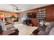 Spacious living room with wood paneling, tile floors, comfortable seating, and an entertainment center at 716 S Franklin Pl, Lakeland, FL 33815