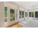 Bright and airy porch with many windows, white tile flooring, and ceiling fan at 716 S Franklin Pl, Lakeland, FL 33815