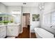 Bright bathroom featuring a soaking tub, marble countertop, and modern fixtures at 717 Frank Lloyd Wright Way, Lakeland, FL 33803
