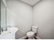 This half bathroom features modern fixtures and a small sink and toilet at 717 Frank Lloyd Wright Way, Lakeland, FL 33803