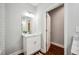 Bathroom vanity with white marble countertop and silver faucet, open door showing bathroom area at 717 Frank Lloyd Wright Way, Lakeland, FL 33803