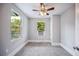 This bedroom includes gray walls, carpeted floors, a ceiling fan and a window air conditioning unit at 717 Frank Lloyd Wright Way, Lakeland, FL 33803