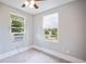 This bedroom features two windows, neutral walls, carpeted floors, and a window air conditioning unit at 717 Frank Lloyd Wright Way, Lakeland, FL 33803