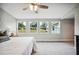 Bedroom featuring neutral carpet, ceiling fan and windows overlooking outdoor scenery at 717 Frank Lloyd Wright Way, Lakeland, FL 33803
