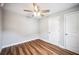 Bedroom with wood-look floors, ceiling fan, white door and trim at 717 Frank Lloyd Wright Way, Lakeland, FL 33803
