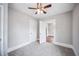 This bedroom features neutral walls, carpeted floors, a ceiling fan and two closet doors at 717 Frank Lloyd Wright Way, Lakeland, FL 33803