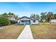 Charming blue craftsman-style home with a lush lawn and inviting front porch at 717 Frank Lloyd Wright Way, Lakeland, FL 33803