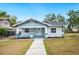 Charming craftsman-style home featuring a quaint front porch, blue siding, and a well-manicured front lawn at 717 Frank Lloyd Wright Way, Lakeland, FL 33803
