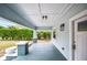 Cozy front porch with painted wood floors and pillars at 717 Frank Lloyd Wright Way, Lakeland, FL 33803