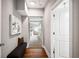Hallway with hardwood floors, bench and view into carpeted bedroom at 717 Frank Lloyd Wright Way, Lakeland, FL 33803