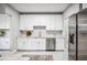 Bright kitchen features white cabinets, stainless steel appliances, and stylish backsplash at 717 Frank Lloyd Wright Way, Lakeland, FL 33803