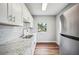 Bright kitchen featuring stainless steel refrigerator, white cabinets, subway tile and marble counters at 717 Frank Lloyd Wright Way, Lakeland, FL 33803