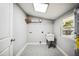 Well-lit laundry room with utility sink, storage shelf, and natural light from a window at 717 Frank Lloyd Wright Way, Lakeland, FL 33803
