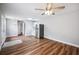 Open living area with wood-look floors, ceiling fan, and kitchen with stainless steel refrigerator at 717 Frank Lloyd Wright Way, Lakeland, FL 33803