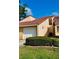 Charming villa featuring a red tile roof, attached garage and manicured landscaping on a sunny day at 733 Carpenters Way # 36, Lakeland, FL 33809