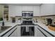 Close-up of a modern kitchen featuring stainless steel appliances and white cabinets at 733 Carpenters Way # 36, Lakeland, FL 33809
