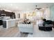 Open-concept living area with a modern kitchen island, comfortable seating, and hardwood floors at 7562 Sw 108Th St, Ocala, FL 24476
