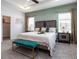 Spacious main bedroom with a tray ceiling, bench, and ample natural light from two windows at 7562 Sw 108Th St, Ocala, FL 24476