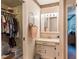 Bathroom with vanity, mirror, and walk-in closet with built-in storage at 7721 Forest Way, Lakeland, FL 33810