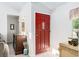 View of foyer with red front door, carpeted floors, and decorative accents at 7721 Forest Way, Lakeland, FL 33810