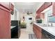 Efficient kitchen featuring dark wood cabinets, white counters, and adjacent living space at 7721 Forest Way, Lakeland, FL 33810