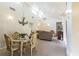 Open-concept living space with a dining table, plush sofa, and vaulted ceilings at 7721 Forest Way, Lakeland, FL 33810