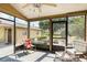 Enclosed sunroom featuring a ceiling fan, comfortable seating, and views of the lush outdoors at 7721 Forest Way, Lakeland, FL 33810