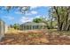 A spacious, grassy backyard featuring an enclosed pool and mature trees at 7741 Merrily Way, Lakeland, FL 33809