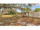 A relaxing wooden swing and custom firepit in the backyard with mature trees at 7741 Merrily Way, Lakeland, FL 33809