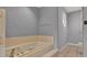 Bathroom area featuring a step-up tub, toilet area, and window at 7741 Merrily Way, Lakeland, FL 33809