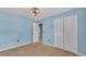 Comfortable bedroom with blue walls, carpet, a closet, and a white trim at 7741 Merrily Way, Lakeland, FL 33809