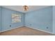 Cozy bedroom featuring light blue walls, neutral carpeting, and a bright window at 7741 Merrily Way, Lakeland, FL 33809