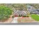 Landscaped home with mature trees, a front lawn, a long driveway, and a red garage door at 7741 Merrily Way, Lakeland, FL 33809