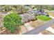An aerial view of a landscaped home, with a red garage door, mature trees, and a front lawn at 7741 Merrily Way, Lakeland, FL 33809